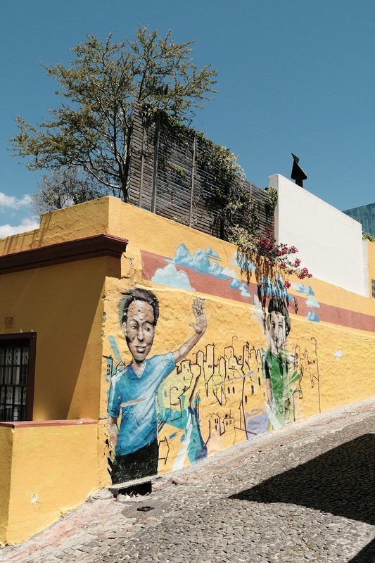 a yellow building with a painting of a boy on it