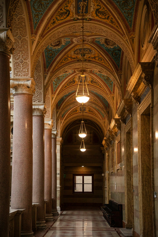 a long hallway with columns and a light hanging from the ceiling
