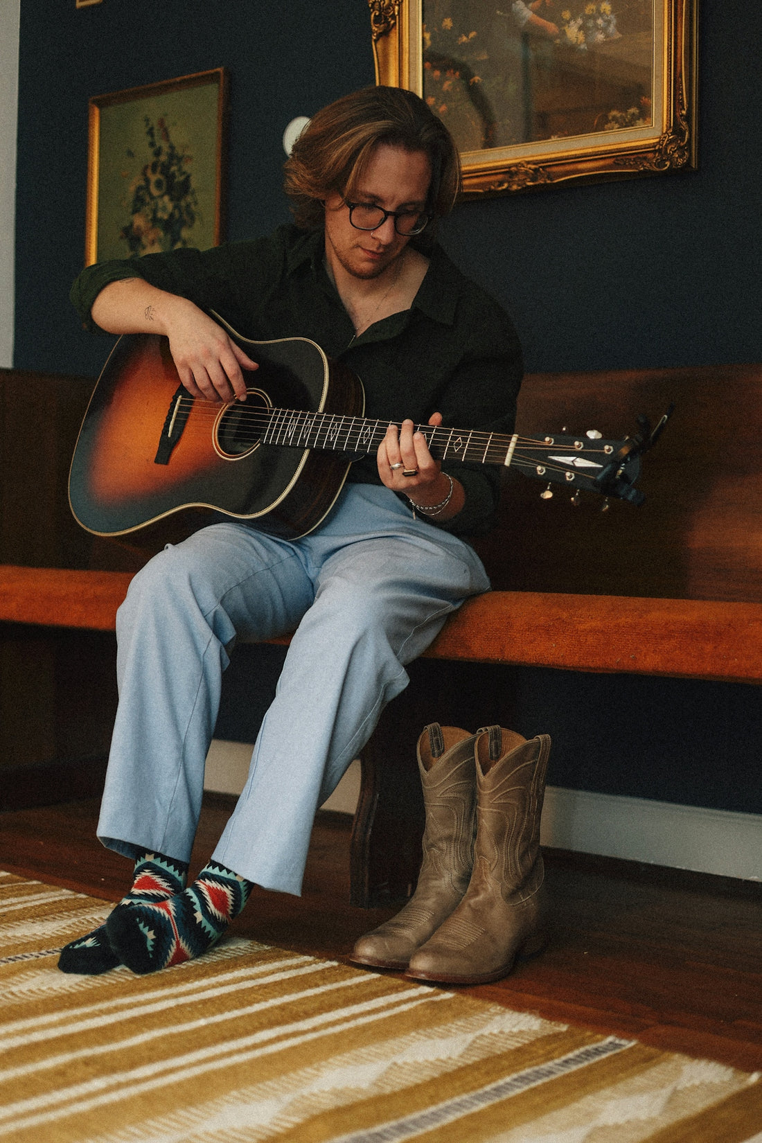 A person sitting on a bench playing a guitar