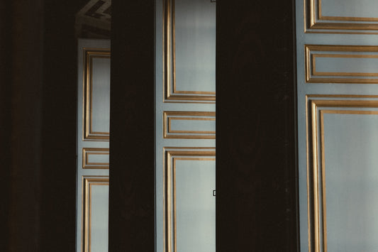 Elegant doors with gold trim are partially obscured.