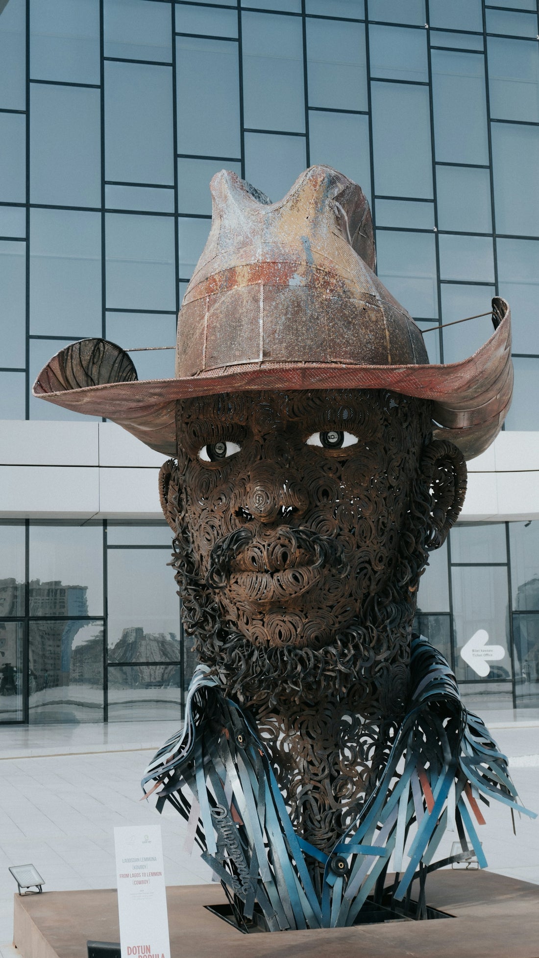 Sculpture of a man wearing a cowboy hat and shirt.